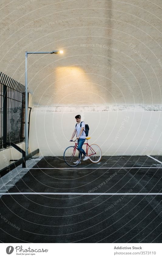 Mann auf dem Fahrrad auf einem Parkplatz Fixie Zyklus urban Rad feststehend Sport Transport Ausrüstung Lifestyle Wand Straße Hipster Mitfahrgelegenheit Pedal