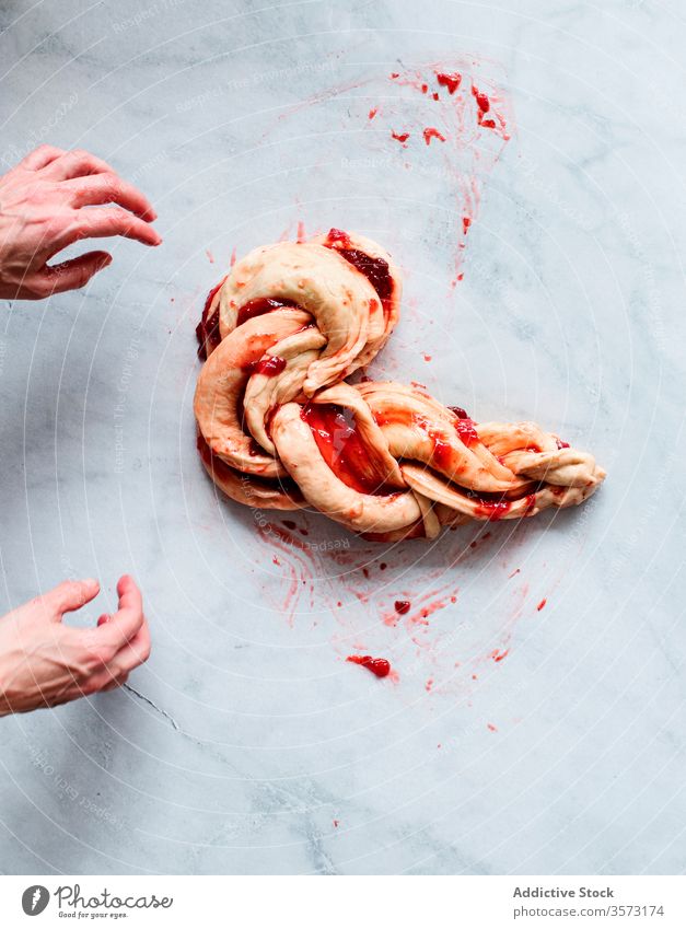 Anonyme Person, die frische Erdbeerbrioche auf einem Marmortisch herstellt Frucht Erdbeeren bewahren Hände Butter Mehl Brotbelag Gebäck Süße Lebensmittel Zucker