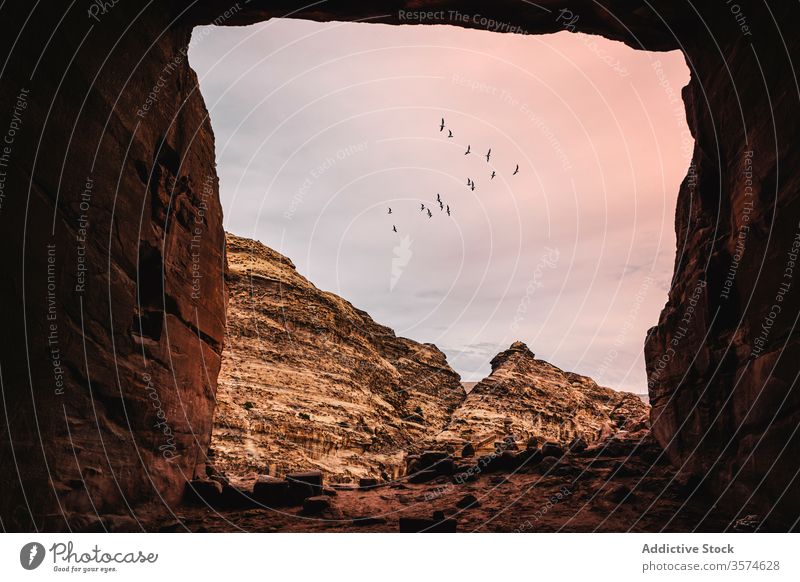 Malerischer Blick aus der Höhle mit quadratischem Eingang Quadrat felsig Berge u. Gebirge Sonnenuntergang wolkig Himmel Schwarm Vogel Petra Jordanien