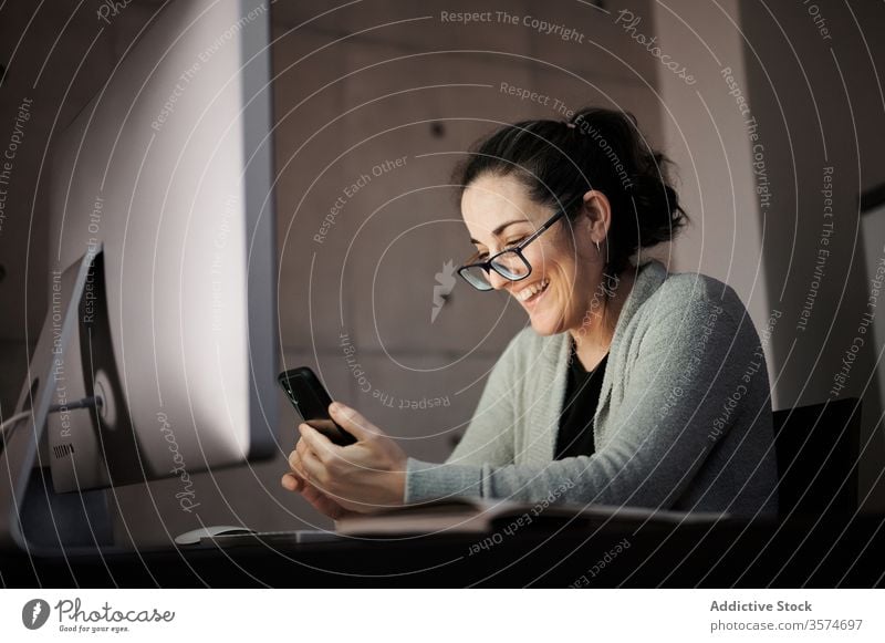 Fokussierte Frau, die zu Hause mit Gadgets arbeitet Arbeit heimwärts Apparatur Smartphone Computer Telearbeit benutzend Browsen jung lässig ernst Konzentration
