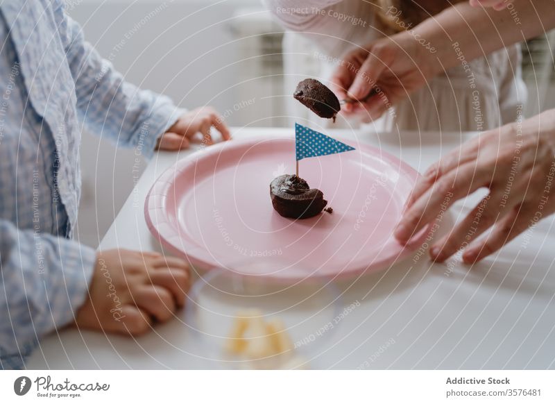 Mutter mit Kindern teilt das Dessert auf Geburtstagsfeier teilen Feiertag Liebe süß Schokolade Zusammensein Muffin Fahne rosa Teller Party heimwärts feiern