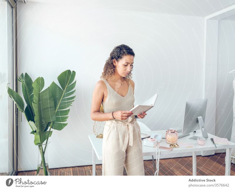 Fröhliche Frau liest Notizbuch im Büro lesen Notebook Notizen Business Lächeln Arbeit Tisch Lehnen palma de mallorca Spanien Stil elegant trendy heiter Glück