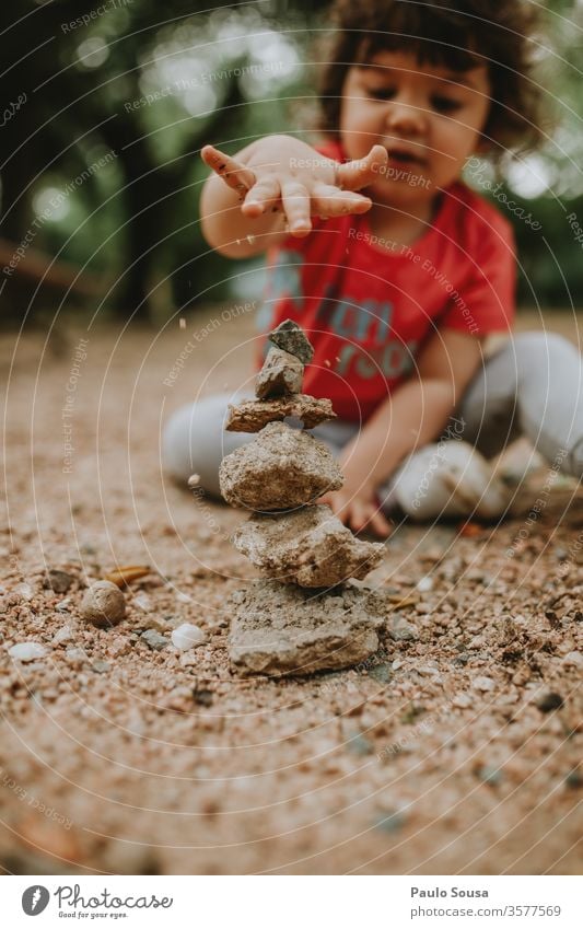 Mit Sand spielendes Kind Steine Kinderspiel Kindheit Spielen im Freien Natur Ausgeglichenheit Gleichgewicht abgestimmt Farbfoto Außenaufnahme Freude