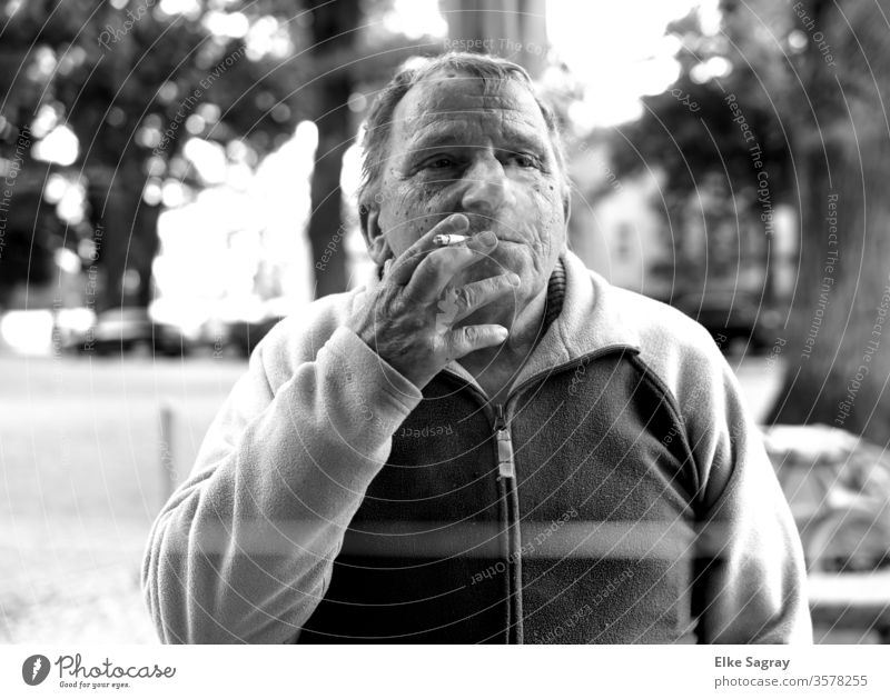 Senior rauchend... Mann Mensch Zigarette Außenaufnahme Rauchen Schwarz und weiß