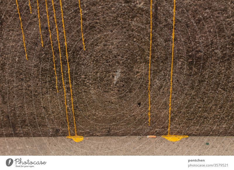 gelbe Spuren aus Farbe laufen strichförmig eine Mauer hinab und bilden farbpfützen . Kreativität. malen kreativität mauer rinnen striche struktur formen Kunst