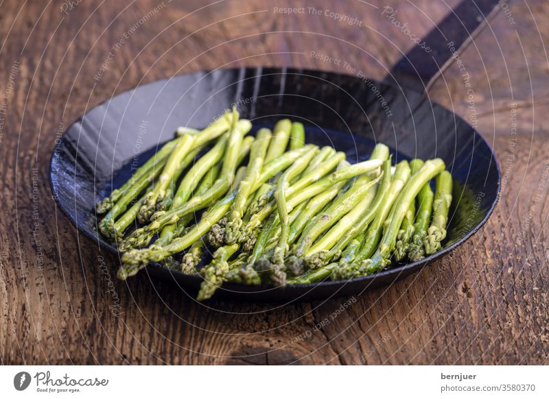 grüner Spargel in einer Eisenpfanne Kochen gesund Essen Grün Pfanne Küche frisch vegetarisch Vorbereitung Gemüse Zutat Mahlzeit schließen Hintergrund Ernährung