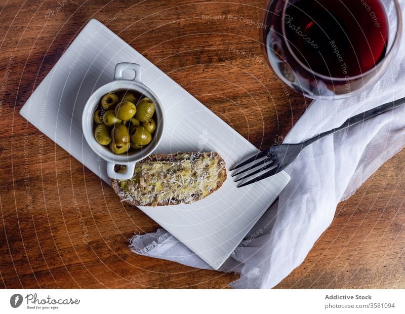 Oliven und Wein auf Holztisch oliv Snack Tisch Küche Bruschetta Weinglas Zuprosten Rotwein Schalen & Schüsseln eingelegt hölzern Belegtes Brot Teller Glas