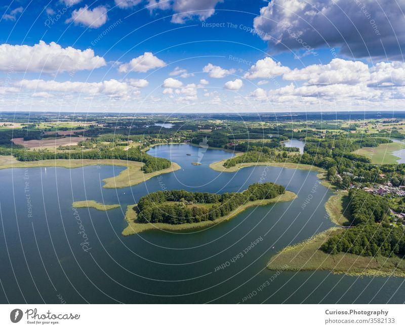 Blick auf kleine Inseln auf dem See in Masuren und im Bezirk Podlasie, Polen. Blaues Wasser und weiße Wolken. Sommerzeit. Blick von oben. Hubschrauber polnisch