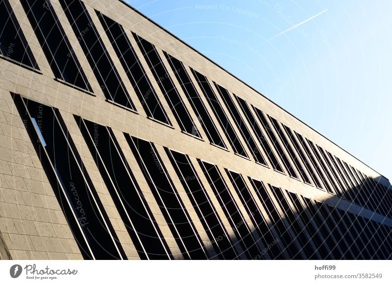 Schattenspiel mit Kondensstreifen am Himmel Luftverkehr Flugzeug Klimawandel Fassade Fenster Jalousie Architektur Bankgebäude Haus Sonnenlicht Licht