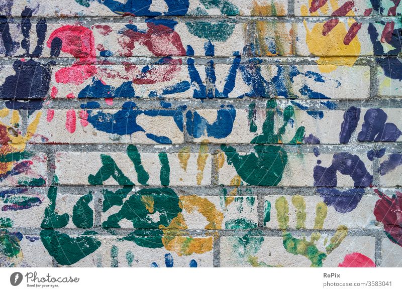 Bunte Handabdrücke an der Wand eines Kindergartens. wall hand finger brick backstein ziegel architektur haus hauswand stadt urban städisch kunst fingerprints