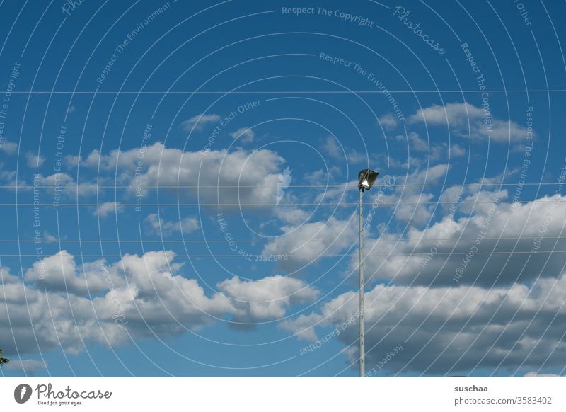 himmel mit wolken, stromkabeln und einem flutlicht Himmel Wolken schönes Wetter Tag Tageslicht Stromkabel Flutlicht Sportplatz Bolzplatz technische Anlage