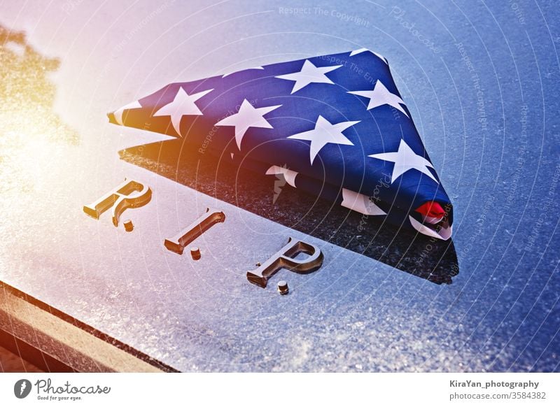 In Dreieck gefaltete amerikanische Flagge auf Marmor-Gedächtnisgrab mit R.I.P.-Text Stars and Stripes Grunge uns 4. Juli Transparente USA Konzept Gedenktag