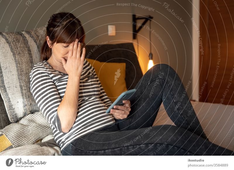 Traurige Frau zu Hause Ärger drücken traurig Smartphone Bett Mitteilung müde depressiont Problematik frustrierter Benutzer erschöpfte Menschen ängstliche Person