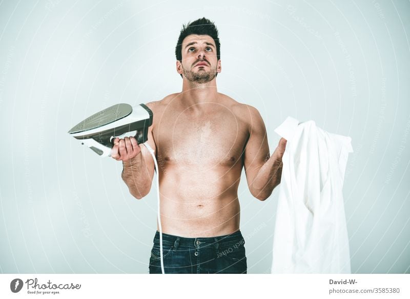 Männer und... - Mann verzweifelt am Bügeleisen Haushalt bügeln Hemd Problem hilflos Hilflosigkeit Klischee typisch Zwei Linke Hände Farbfoto Bekleidung