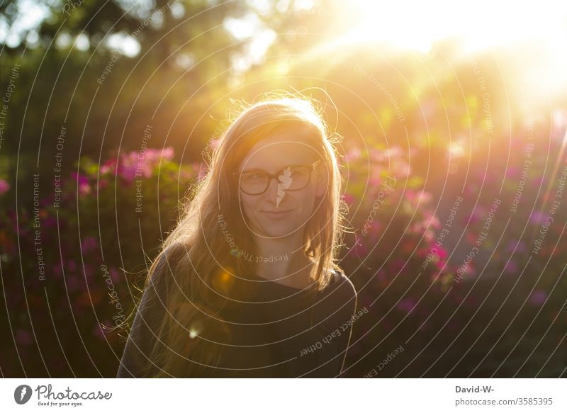 Frau mit Brille im Sonnenschein und Gegenlicht Junge Frau sonnenstrahlen natürlich Erwachsene Farbfoto Sonnenstrahlen 1 Sonnenlicht 18-30 Jahre Außenaufnahme