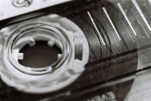 Makro-Nahaufnahme eines alten Plastikkassettenbandes in Schwarz-Weiß Musik Rolle SCHWARZ-WEIß schwarz-weiß schwarz auf weiß altmodisch veraltet Oldschool 80s
