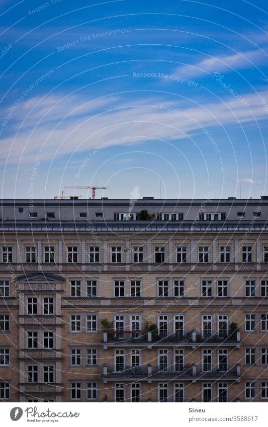 Himmel über Berlin Fassade Häuserfront Mehrfamilienhaus Mietshäuser Balkone Dachterrasse Baukran Blauer Himmel Wolken Cirruswolke Sommer warm gutes Wetter