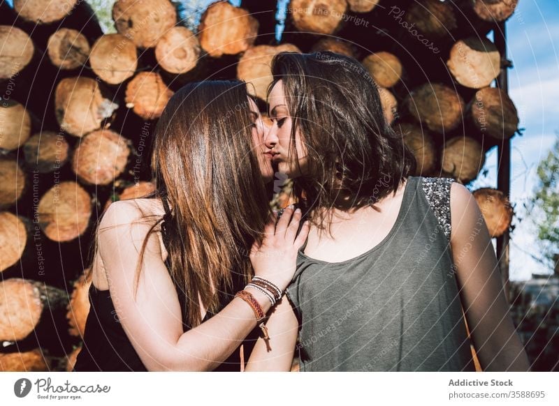 Junges lesbisches Paar küsst sich Frauen Kuss rustikal Wand Totholz Sommer gleichgeschlechtlich Sommerzeit tagsüber jung Angebot Homosexualität lgbtq schwul