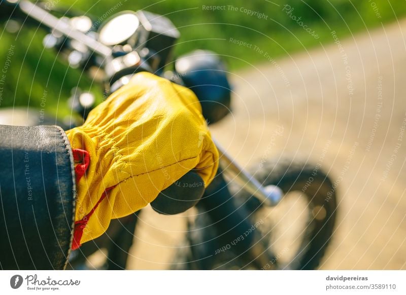 Bikerhand mit Handschuhen, die den Lenker greifen. gelb Detailaufnahme Motorrad altehrwürdig Mann benutzerdefiniert Fahrrad retro Reiter Fahrzeug Verkehr jung