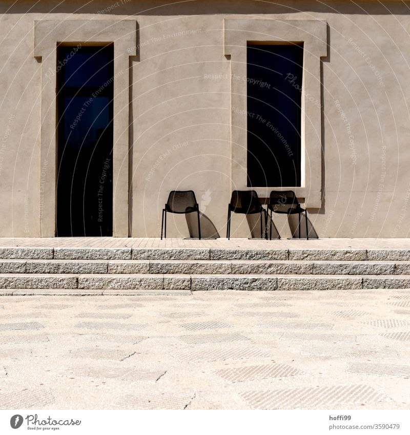 Drei Stühlen in der Sonne warten auf Gäste drei Stuhl Stuhlgruppe Stuhlreihe Sandsteinmauer Wand Fassade Steinwand Ordnung Linie minimalistisch Hintergrundbild