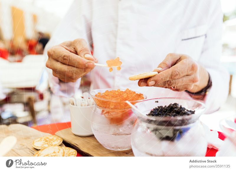 Mann serviert Snack mit Kaviar Lebensmittel dienen Fladenbrot Anlasser Amuse-Gueule Büffet setzen Person Tradition lecker geschmackvoll Mahlzeit Speise