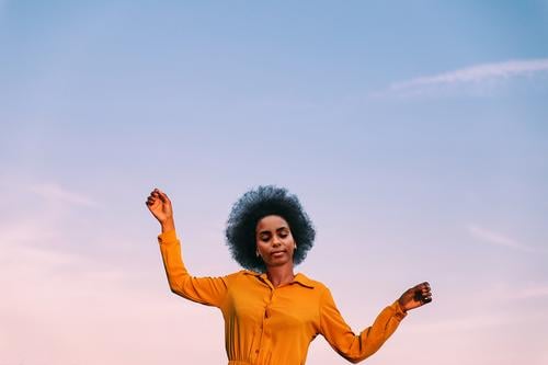 schwarze Frau, die mit dem Wind tanzt Tanzen im Freien Blauer Himmel Mädchen jung Menschen Porträt Lifestyle cool lieblich Garten gelbe Blume Außenseite Natur