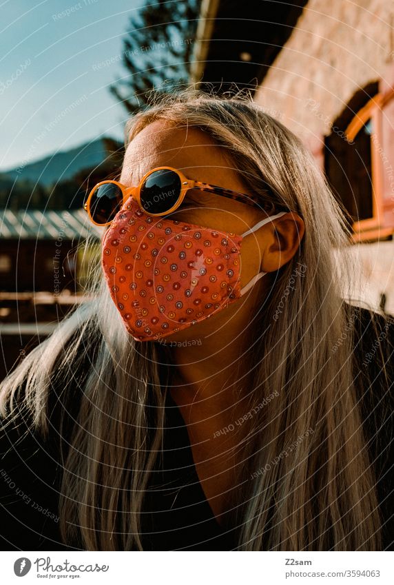 Frau mit Corona-Maske im Biergarten corona virus frau biergarten bayern schutz sonnenbrille gesundheit ansteckung soziales leben öffentlichkeit portrait blond