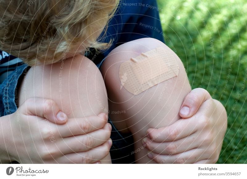 Junge mit einem Gips auf seinem verletzten Knie Unterstützung Band bandagieren bandaid Kind Sauberkeit deckend geschnitten erste Hände Hilfsbereitschaft wehtun