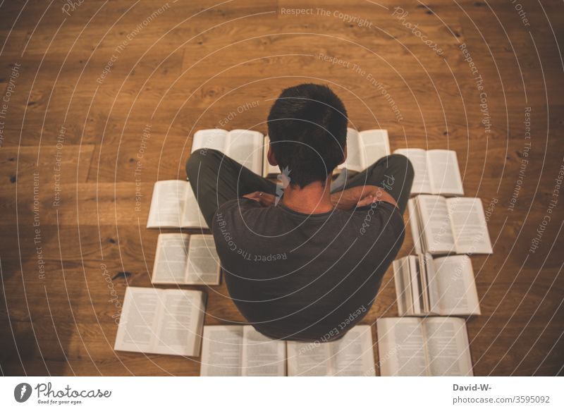 Mann sitzt auf dem Boden umringt von Büchern Buch lesen bildung gebildet lernen Parkettboden Holzboden Buchseite Bildung Studium Schule Farbfoto Weisheit