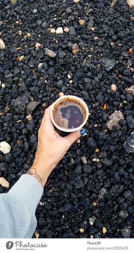 Frische heiße Kaffeetasse in der Hand haltend auf dem Boden, morgendliches Wandern, Reisen Tasse Café trinken Glas frisch lecker braun Lebensmittel cool