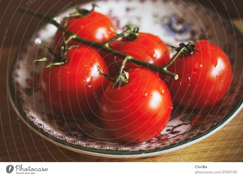 Frische Rispen Tomaten auf einem bunten Teller genießen lecker Gesunde Ernährung Vegetarische Ernährung Nahaufnahme frisch Farbfoto Lebensmittel Frucht