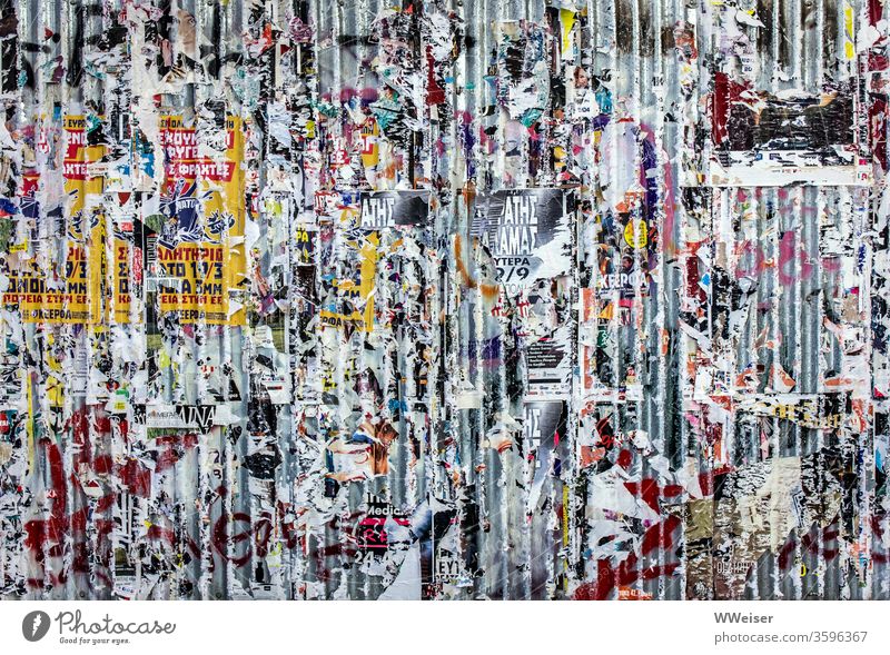 Wand mit Plakatresten Wellblech Reste Plakate Zeitungen Zettel zerrissen bunt Fassade griechisch Athen Strukturen Papier Druck Metall Wellblechwand Farben
