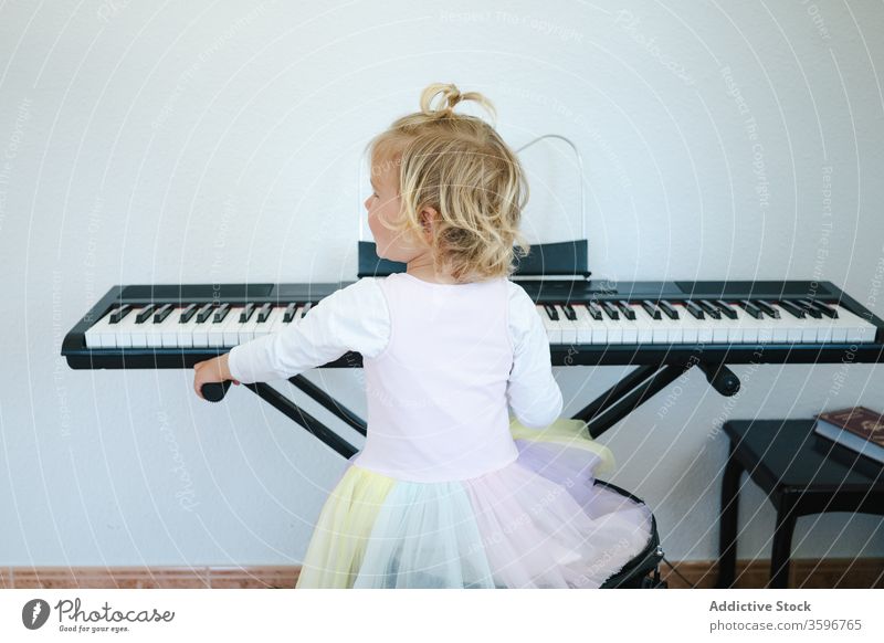 Süßes Mädchen lernt modernes Klavierspielen lernen heimwärts Synthesizer Kindheit niedlich Musik Klasse Rock Schulmädchen Bildung üben vorbereiten wenig
