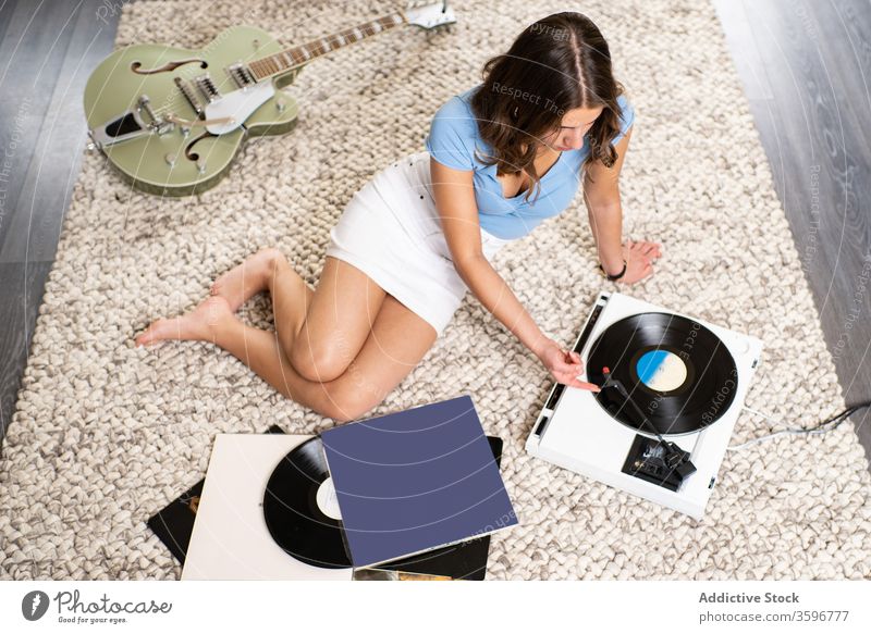 Junge Frau hört Musik auf Vinylplatte Aufzeichnen Scheibe Spieler zuhören heimwärts ruhen retro meloman jung Klang Melodie Gesang Audio Hobby Gerät unterhalten