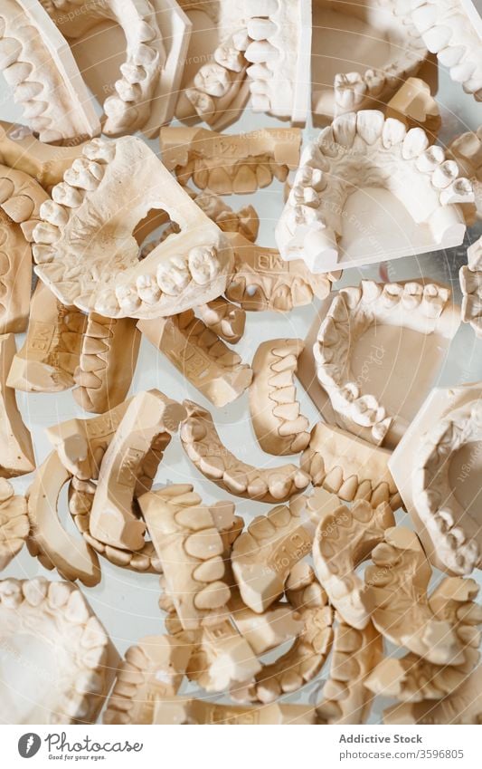 Satz von Zahnabdrücken im Labor dental gießen Kiefer Model kieferorthopädisch künstlich Zahnmedizin Zähne Kulisse verputzen Gips Hintergrund abstrakt Haufen