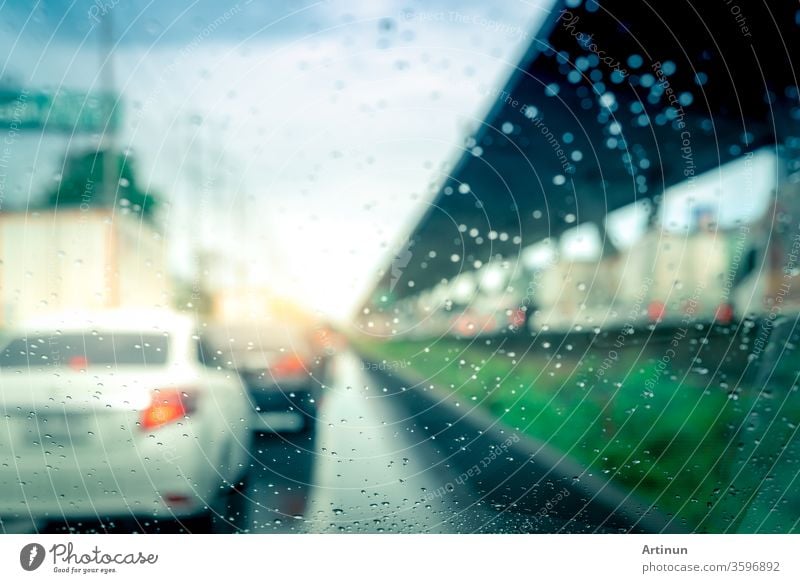 Regentropfen auf der Windschutzscheibe. Auto fährt an einem regnerischen Tag auf Asphaltstrasse. Windschutzscheibe eines Autos mit Regentropfen auf Glaswindschutzscheibe. Verkehrsstau an einem Regentag. Schlechtes Wetter an einem stürmischen Tag. Reisen mit dem Auto.