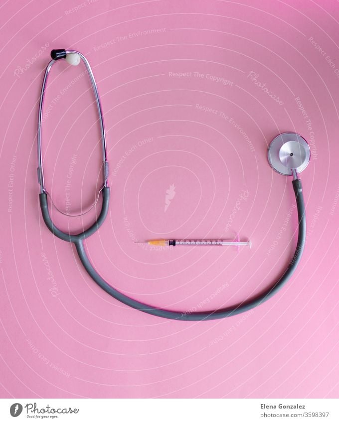 Draufsicht auf das medizinische Konzept mit Stethoskop und Spritze auf rosa Hintergrund zur Prävention von Coronaviren. Covid-19-Kit. Platz zum Kopieren