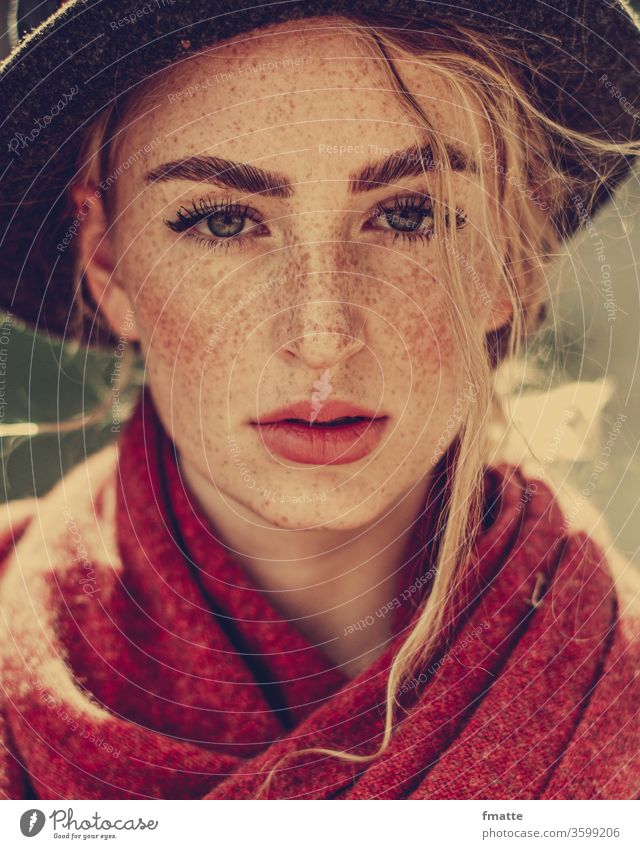 Junge Frau mit Sommersprossen, Hut und rotem Schal Frauengesicht hut Strähne blond Schönheit Blick in die Kamera augen Porträt Jugendliche Erwachsene