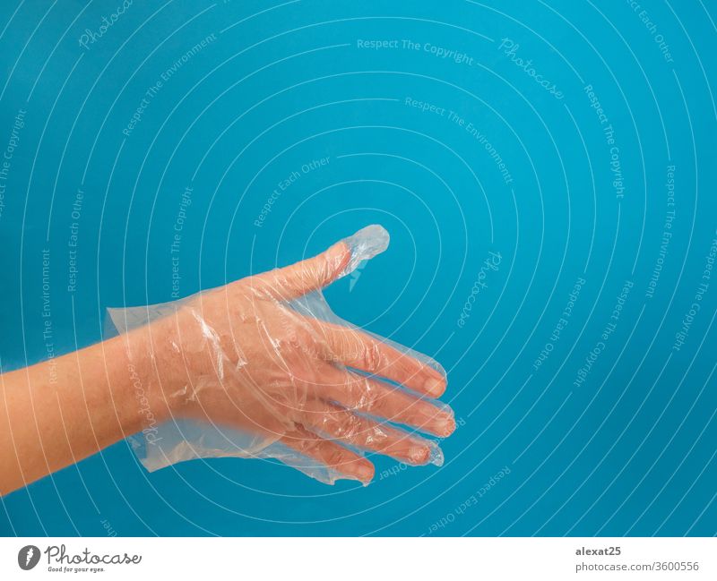 Hand mit Plastikhandschuh vor Handschlag auf blauem Hintergrund mit Arme Körper Pflege Sauberkeit Nahaufnahme Bekleidung Textfreiraum covid-19 Einwegartikel