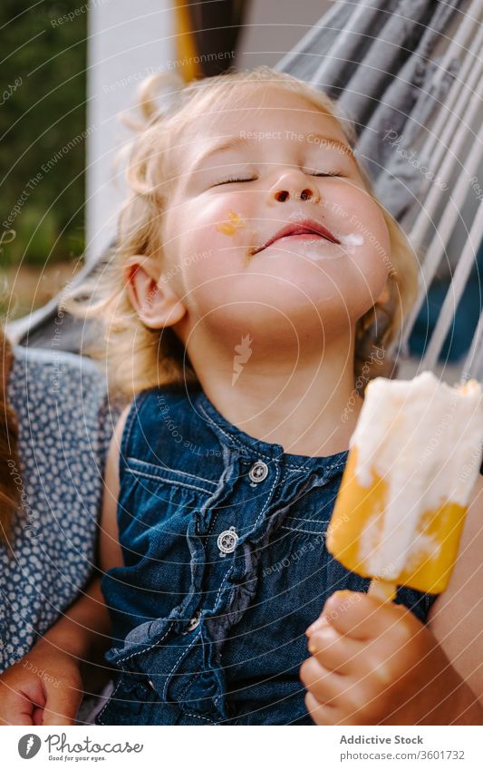 Verträumtes Mädchen mit Eis in der Hängematte essen Speiseeis Stieleis Sommer Terrasse selbstgemacht Kind wenig Inhalt Kindheit sich[Akk] entspannen sorgenfrei