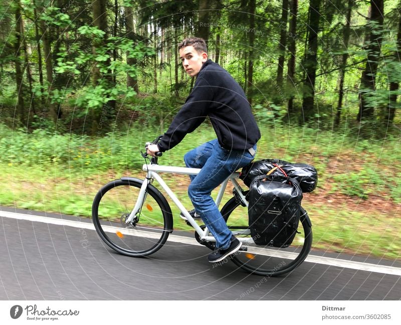 Junger Mann auf Fahrradtour Jugendlicher unterwegs Gepäck Familienurlaub aktiv attraktiv