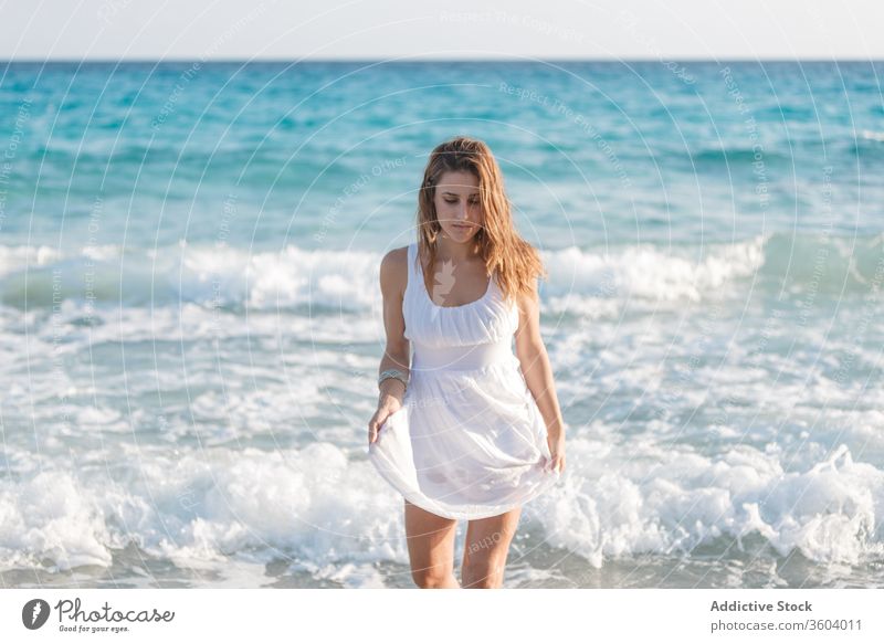 Zärtliche Frau in weißem Kleid am Meeresufer im Sommer MEER Urlaub Angebot Strand Meereslandschaft Feiertag genießen Gelassenheit türkis Wasser sonnig Wetter