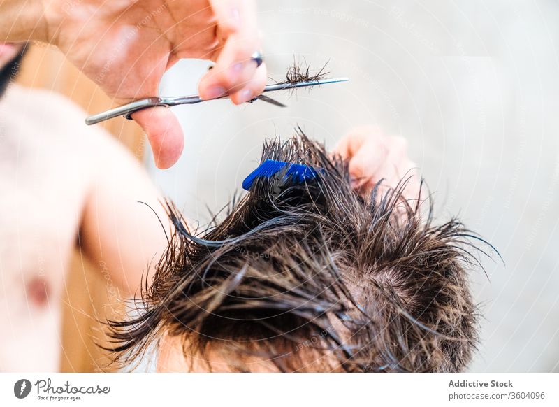 Pflanzenfriseur schneidet Haare eines Mannes mit einer Friseurschere im Badezimmer geschnitten Behaarung Scheren Werkzeug heimwärts Gerät Haarpflege Hand