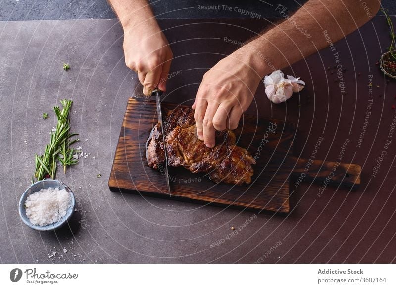 Hände beim Schneiden von Rindersteak ribeye Steak gegrillt schwarz angus Grillrost Lebensmittel Fleisch Küche Beefsteak gebraten geschmackvoll aufgeschnitten