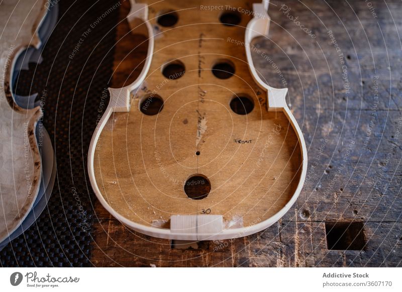 Resonanzboden einer handgefertigten Geige auf schäbiger Holzoberfläche im Arbeitsraum Prozess Werkstatt Golfloch Handwerk Instrument hölzern Verarbeitung