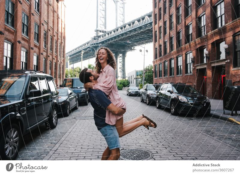 Glückliches Paar umarmt und küsst sich auf dem Bürgersteig in der Stadt Heben Freundin Kuss Zusammensein Straße Umarmung Liebe Großstadt New York State amerika