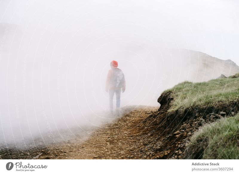 Unbekannter männlicher Reisender in nebligem Hochland Nebel Mann Spaziergang Berge u. Gebirge Entdecker mystisch Landschaft Island Wetter Straße kalt Saison