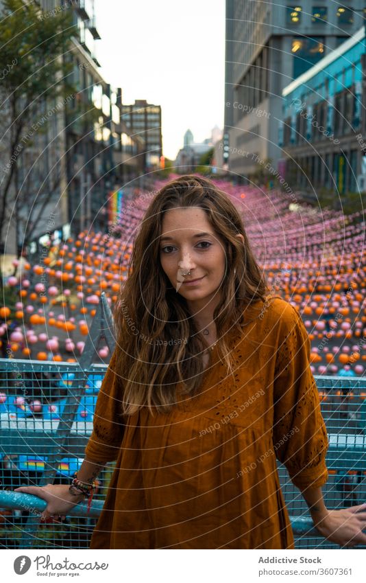 Junge Frau gegen Stadt mit Girlanden Großstadt Stadtfest Straße Stil farbenfroh Urlaub Kleid Montreal Kanada modern attraktiv Architektur Tradition