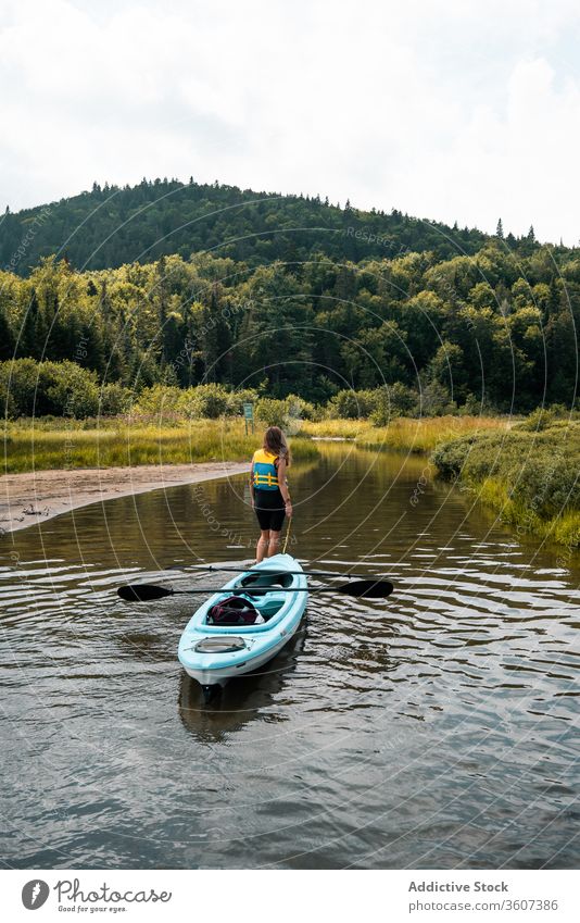 Anonyme Frau mit Boot im Fluss stehend Hügel Natur bewundern reisen Nationalpark la mauricie Quebec Kanada Sauberkeit Küste Kajak Wasser grün Ausflug Reise