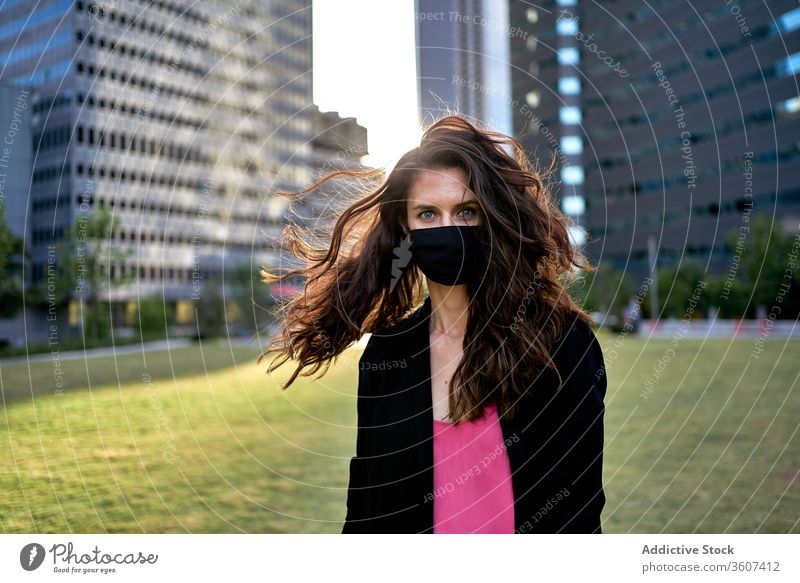 Seriöse Frau mit medizinischer Maske in der Stadt Seuche Coronavirus Mundschutz Großstadt Bund 19 behüten verhindern Sicherheit Stadtzentrum ernst modern